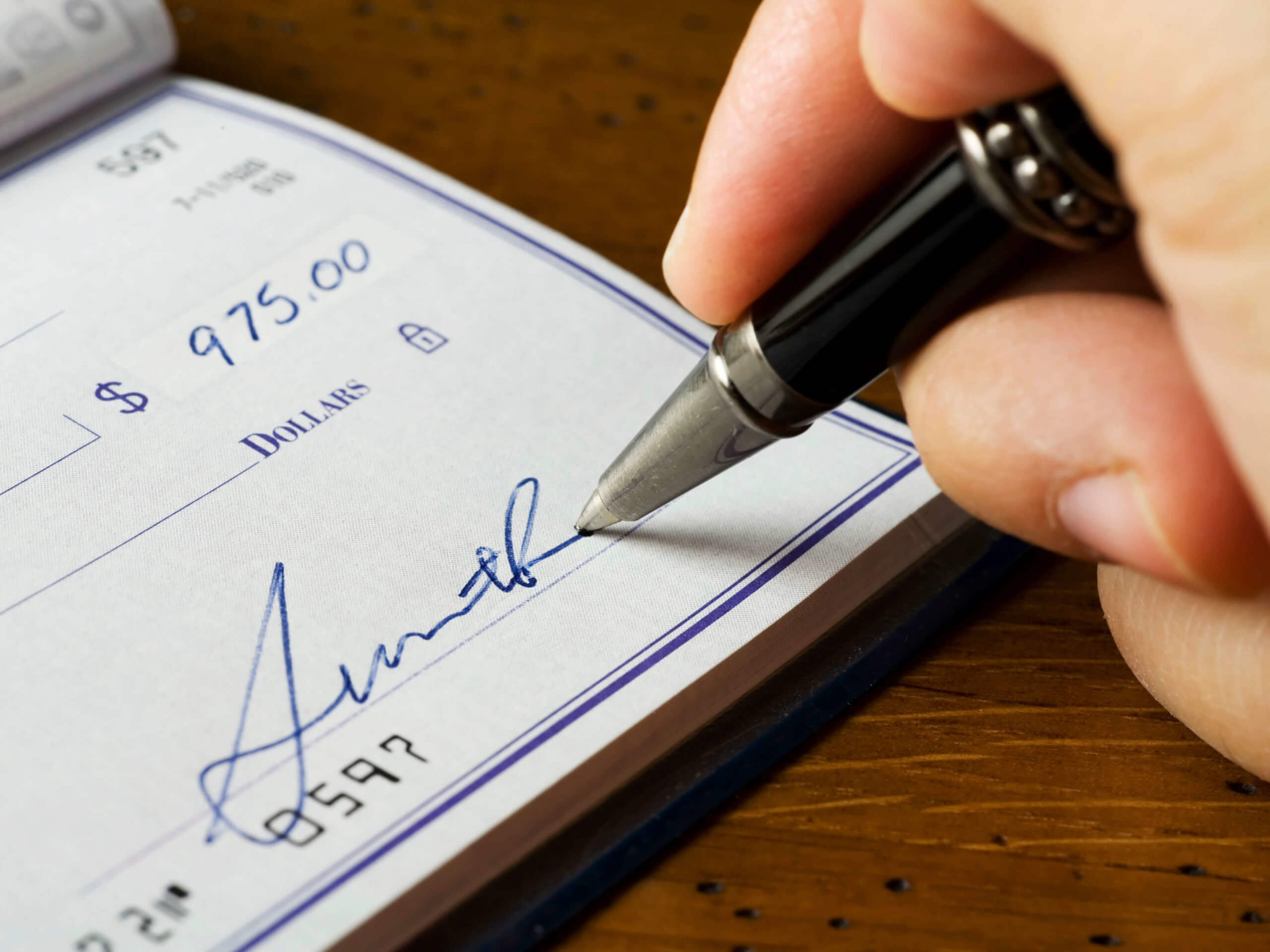 close up of person signing a check