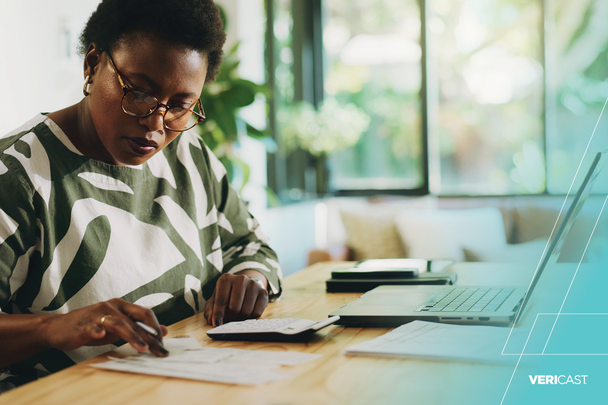 Woman looking over her banking paperwork while on the computer