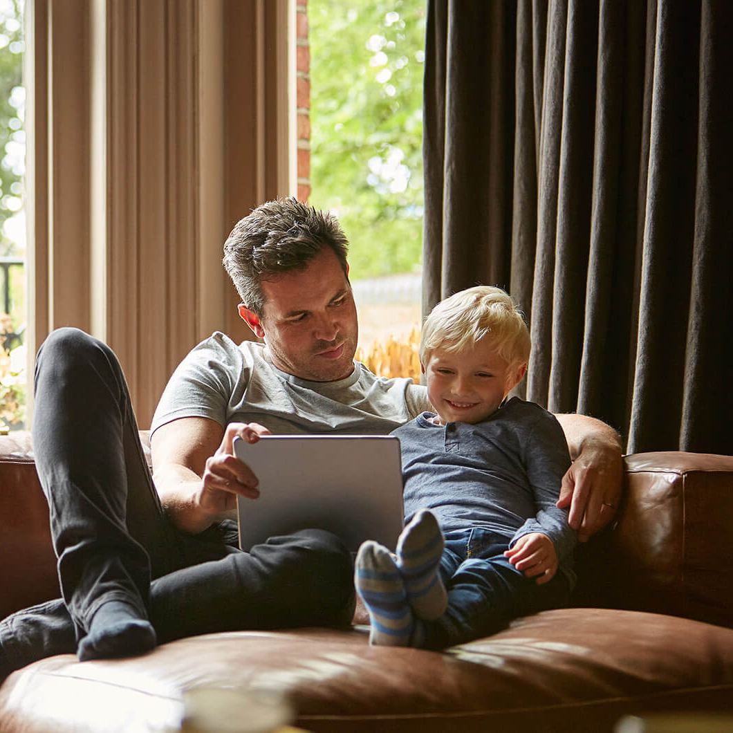 father and son viewing tablet